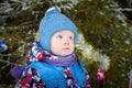 Young small boy walking and having photo shoot in park or forest full of snow in a cold winter day. Male child having Royalty Free Stock Photo