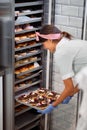 A young small business female owner is packing a closet with delicious handmade donuts in a candy workshop. Pastry, dessert, sweet