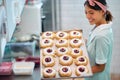 A young small business female owner is passionate about her handmade delicious donuts. Pastry, dessert, sweet, making