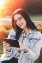 Young smart brunette woman in glasses using tablet outdoor Royalty Free Stock Photo