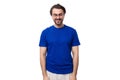 young smart caucasian man with dark well-groomed hair and a beard in a blue t-shirt on a white background