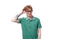 young smart european guy with red hair in glasses thinks and scratches his head Royalty Free Stock Photo