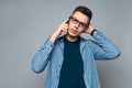 Young smart guy with glasses speaks on phone Royalty Free Stock Photo