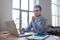 Young smart man with glasses looking at a laptop. Royalty Free Stock Photo