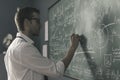 Young smart mathematician drawing on the chalkboard