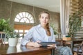 Young smart woman sitting with laptop gadget and working