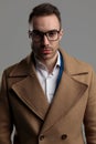 Young smartcasual model wearing glasses and long coat