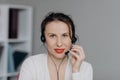 Young Smile Operator Working with a Headset and Happy Smile Face to the Camera. Young Beautiful Woman Operator with Royalty Free Stock Photo