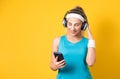 Young smile vitality woman with earphones enjoying while listen music wearing sport clothing - sportswear, isolated on yellow