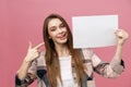 Young smile woman standing pointing her finger at a blank board. Royalty Free Stock Photo