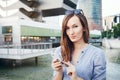 Young smiley well-dressed Caucasian business woman uses smart-phone. Royalty Free Stock Photo