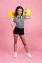 Young smiling african teenage girl standing and holding skateboard Royalty Free Stock Photo