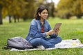 Young Smiling Arab Woman Relaxing In Park With Digital Tablet Royalty Free Stock Photo