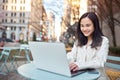 Young smiling Asian business woman or student using laptop outdoors. Royalty Free Stock Photo