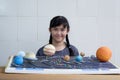 Asian girl showing her homemade solar system model for science homework project Royalty Free Stock Photo