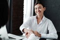 Young smiling asian girl sitting at the table concludes negotiations shaking hand to a woman taking her to work Royalty Free Stock Photo