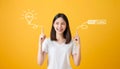 Young smiling Asian woman pointing hands to light bulb with text ideas and loading brainstorm on yellow background.