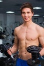 Young smiling athlete lifting weights in the gym Royalty Free Stock Photo