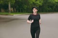 Young smiling athletic beautiful brunette girl in black uniform, cap training doing sport exercises, running, jogging Royalty Free Stock Photo