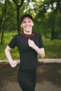 Young smiling athletic beautiful brunette girl in black uniform and cap training doing sport exercises, running and Royalty Free Stock Photo