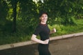 Young smiling athletic beautiful brunette girl in black uniform and cap training doing sport exercises, running and Royalty Free Stock Photo