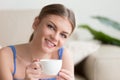 Young smiling attractive woman enjoying coffee looking at camera