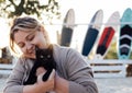 Young smiling attractive woman hugs a black kitten on the sand beach Royalty Free Stock Photo