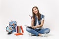 Young smiling attractive woman student in headphones listen music holding notebook, pencil near globe, backpack, school Royalty Free Stock Photo