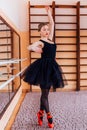 Young Smiling Ballerina Wearing black Tutu Doing exercise in training hall