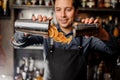 Young smiling barman pouring slices of fresh orange fruit Royalty Free Stock Photo