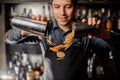 Young smiling bartender pouring slices of fresh orange fruit Royalty Free Stock Photo