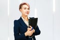 Young smiling beautiful business lady holds documents and pen