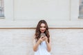 Young smiling beautiful girl using her phone outdoors Royalty Free Stock Photo