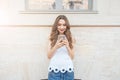 Young smiling beautiful girl using her phone outdoors Royalty Free Stock Photo