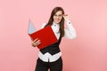 Young smiling beautiful successful business woman in glasses holding red folder for papers document on pink Royalty Free Stock Photo