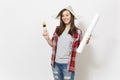 Young smiling beautiful woman in casual clothes and newspaper hat holding paint brush and wallpaper roll isolated on Royalty Free Stock Photo