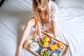 Young Smiling Beautiful Woman Having Breakfast in Bed in Cozy Hotel Room Royalty Free Stock Photo