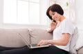 Young smiling beautiful woman with phone and laptop on the sofa Royalty Free Stock Photo