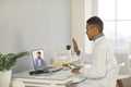 Young smiling black man doctor therapist making online consultation
