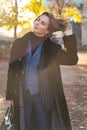 Young blond short-haired woman in striped jacket, jeans and vest touches hair Royalty Free Stock Photo