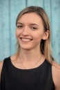 Young smiling blonde brown-eyed girl in black dress against blue Royalty Free Stock Photo