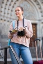 Young smiling blonde girl is leafing through the booklet