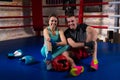 Young smiling boxing couple sitting near lying boxing gloves and Royalty Free Stock Photo