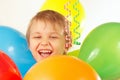 Young smiling boy with festive balloons and streamer
