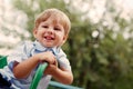 Young Smiling Boy Sitting Outdoors on Playground Royalty Free Stock Photo