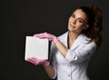 Young smiling brunette woman doctor therapist nurse in white uniform and protective gloves holding blank paper sheet