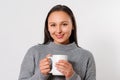 Young smiling brunette woman girl in a warm sweater with a cup of hot coffee. on white Royalty Free Stock Photo