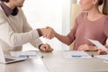 Young smiling business partners shaking hands, group meeting in Royalty Free Stock Photo