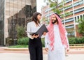 Young smiling business woman and arab man client negotiating contract at outdoor meeting Royalty Free Stock Photo