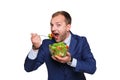 Young smiling businessman eating green salad isolated on white background. Royalty Free Stock Photo